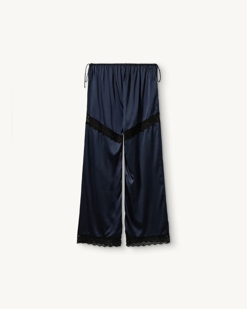 Lejące, jedwabne spodnie Cata Lace The Garment ze średnim stanem i prostą, luźną nogawką. Wiązane na bokach bioder. Wykończone zmysłową koronką. Idealne na co dzień i do wieczorowej, eleganckiej stylizacji. 