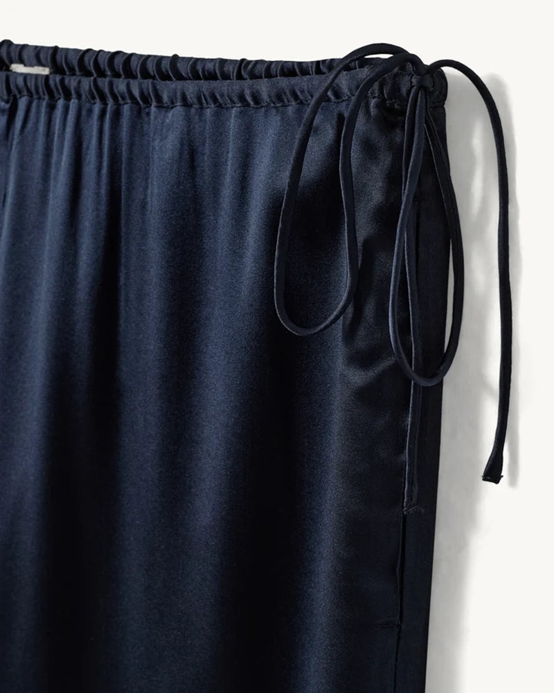 Lejące, jedwabne spodnie Cata Lace The Garment ze średnim stanem i prostą, luźną nogawką. Wiązane na bokach bioder. Wykończone zmysłową koronką. Idealne na co dzień i do wieczorowej, eleganckiej stylizacji. 