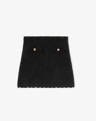 Lekko trapezowa, mini spódnica Chenille Crochet Black marki GANNI z dzianiny z bawełny organicznej o szydełkowym splocie. Zapinana na zamek błyskawiczny. Posiada dwie naszywane kieszenie z patkami, ozdobione złotymi guzikami. U dołu wykończona delikatną falbanką.&nbsp;

-Trapezowy krój

-Ozdobne guziki

-Szydełkowy splot

-Zamów spódnicę w rozmiarze, który nosisz zazwyczaj