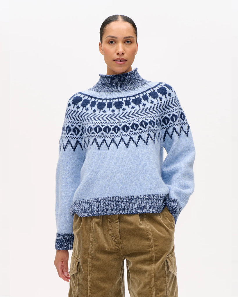 Ciepły, luźny sweter Ciana Blue z wysokim kołnierzem, raglanowymi rękawami oraz ściągaczem przy kołnierzu, mankietach i dole. Ma piękny dwukolorowy szkocki wzór. Wykonany z miękkiej mieszanki wełny. Idealny na chłodne dni.