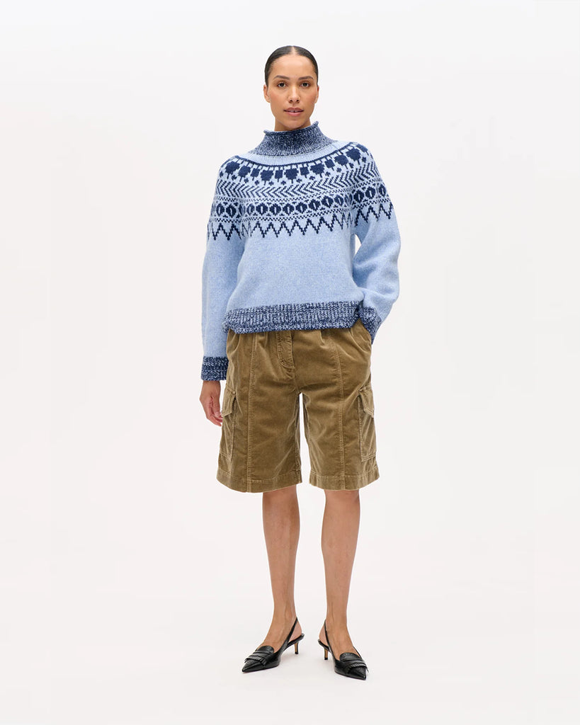 Ciepły, luźny sweter Ciana Blue z wysokim kołnierzem, raglanowymi rękawami oraz ściągaczem przy kołnierzu, mankietach i dole. Ma piękny dwukolorowy szkocki wzór. Wykonany z miękkiej mieszanki wełny. Idealny na chłodne dni.