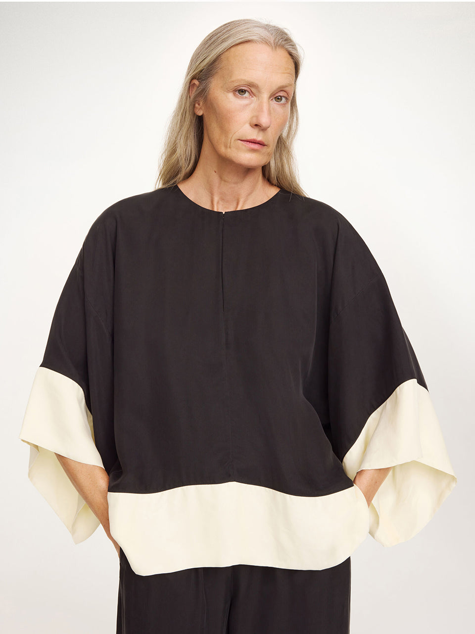 Elegancka, luźna bluzka Cicie Black White By Malene Birger o kwadratowym kroju, z głębokim dekoltem z zapięciem i szerokimi, krótkimi rękawami. Zapinana na haftkę i zatrzask. Wykonana z przewiewnej i gładkiej mieszanki cupro. Bluzka będzie idealną częścią stylizacji na eleganckie, wieczorne wyjścia.&nbsp;

-Luźny, kwadratowy krój

-Głęboki dekolt z zapięciem&nbsp;

-Zamów bluzkę w swoim standardowym rozmiarze