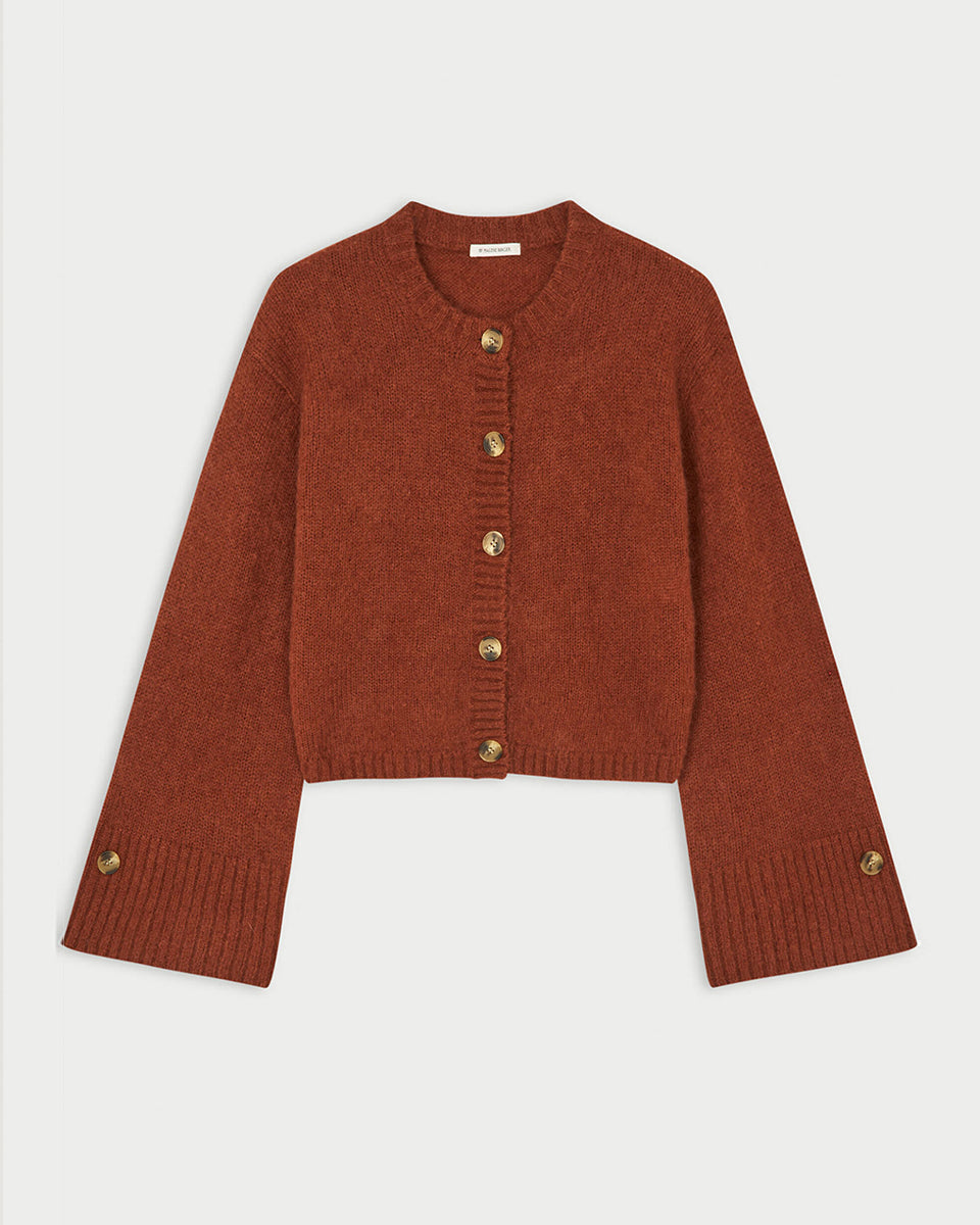 Krótki, swobodnie układający się sweter Cierrou Soft By Malene Birger Spiced Berry w rudym odcieniu. Ma okrągły dekolt i długie, lekko rozszerzane rękawy. Zapinany na rząd guzików. Dodatkowe, mniejsze guziki umieszczono również jako subtelny akcent na mankietach rękawów. Wykończony ściągaczami. Wykonany z ciepłej mieszanki wełny i moheru.

-Rozszerzane rękawy&nbsp;

-Dzianina z wełną i moherem

-Zamów sweter w swoim standardowym rozmiarze&nbsp;
