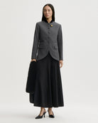 Dopasowana, jednorzędowa marynarka Claye By Malene Birger Dark Grey Melange w stylu vintage ze stójką. Zapinana na rząd drobnych, dyskretnych guzików. Fason charakteryzuje się mocno zaznaczoną, strukturalną linią ramion oraz zaokrąglonym dołem. U dołu po obu stronach umieszczono symetryczne kieszenie z klapkami, a dopasowane, proste rękawy dopełniają elegancki, formalny charakter. Posiada podszewkę i kieszeń wewnętrzną.&nbsp;

-Jednorzędowy fason

-Kontrastowa stójka

-Dopasowany krój