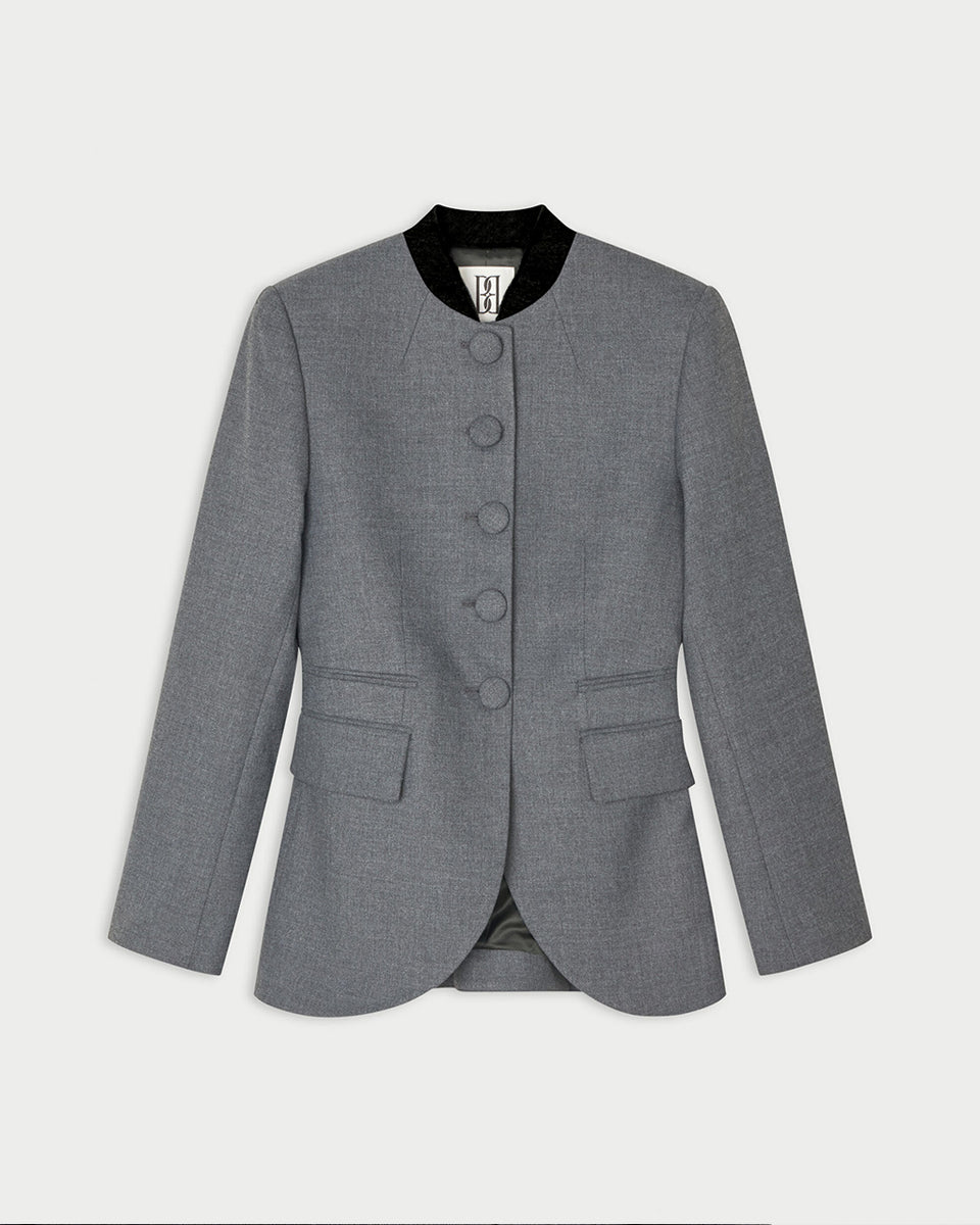 Dopasowana, jednorzędowa marynarka Claye By Malene Birger Dark Grey Melange w stylu vintage ze stójką. Zapinana na rząd drobnych, dyskretnych guzików. Fason charakteryzuje się mocno zaznaczoną, strukturalną linią ramion oraz zaokrąglonym dołem. U dołu po obu stronach umieszczono symetryczne kieszenie z klapkami, a dopasowane, proste rękawy dopełniają elegancki, formalny charakter. Posiada podszewkę i kieszeń wewnętrzną.&nbsp;

-Jednorzędowy fason

-Kontrastowa stójka

-Dopasowany krój