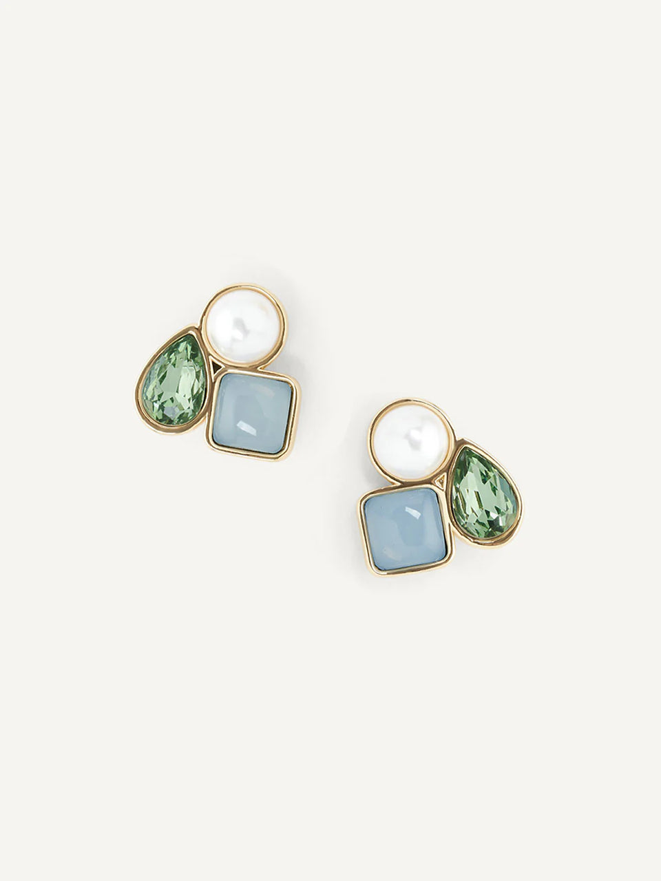 Geometryczne kolczyki Clemence Studs marki Olive&amp;Piper z asymetryczną kompozycją trzech różnych elementów: okrągłej masy perłowej, kwadratowego kamienia w błękitnym odcieniu oraz lśniącej cyrkonii w kształcie zielonej łezki. Zapinane na sztyft.

Hipoalergiczne. Bez niklu.

Kolczyki nie podlegają zwrotowi ani wymianie ze względów higienicznych.