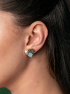 Geometryczne kolczyki Clemence Studs marki Olive&amp;Piper z asymetryczną kompozycją trzech różnych elementów: okrągłej masy perłowej, kwadratowego kamienia w błękitnym odcieniu oraz lśniącej cyrkonii w kształcie zielonej łezki. Zapinane na sztyft.

Hipoalergiczne. Bez niklu.

Kolczyki nie podlegają zwrotowi ani wymianie ze względów higienicznych.