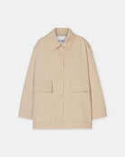 Cienki, krótki, beżowy płaszcz Short coat 97949 CLOSED o luźnym fasonie i prostym kroju. Posiada szerokie, długie rękawy, kołnierzyk i duże, przednie kieszenie z klapkami. Zapinany za pomocą zatrzaskowych guzików