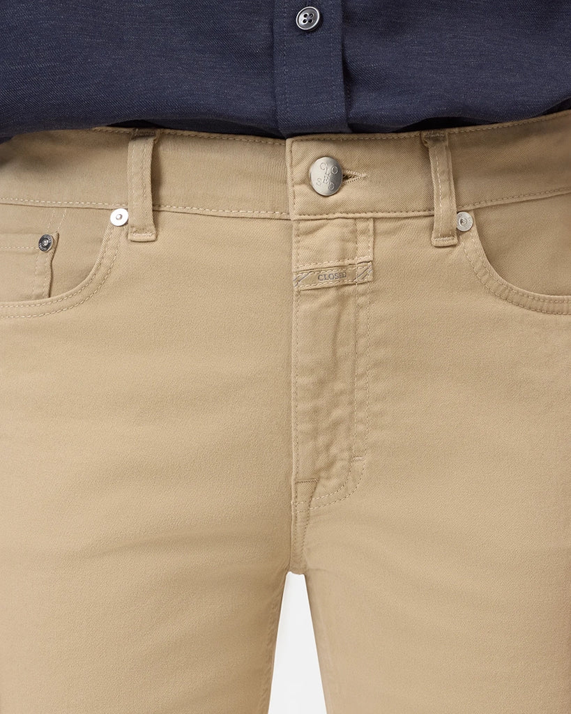 Beżowe jeansy Milo marki CLOSED ze średnim stanem i prostą, luźną i skróconą nogawką. Przylegające w biodrach. Spodnie mają pięć kieszeni. Zapinane na guzik i zamek błyskawiczny. Przy rozporku posiadają niewielką, charakterystyczną dla marki naszywkę z logo CLOSED