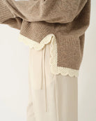 Miękki, luźny sweter Como Crochet Beige Melange z długim rękawem i dekoltem w serek. Dzięki krótszemu przodowi i dłuższemu tyłowi tworzy on korzystną dla sylwetki, swobodnie układającą się linię. U dołu wykończony jest delikatną koronką dodającą subtelnego charakteru. Wykonany z mieszanki wełny i kaszmiru.&nbsp;

-Dekolt w serek

-Wykończony pasem z koronki

-Tkanina z wełną i kaszmirem