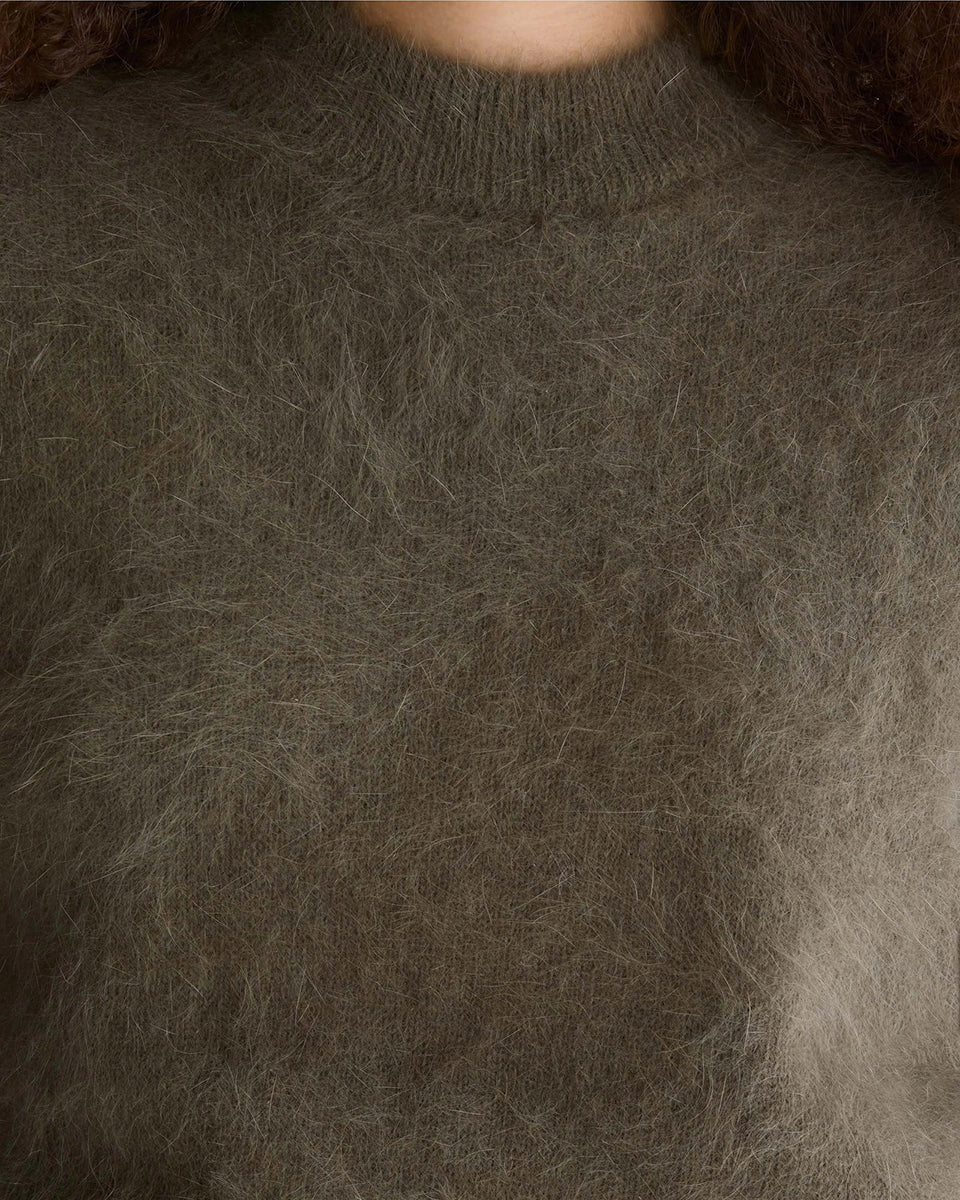Miękki sweter z dzianiny Dateko Dusty Olive marki Bellerose z okrągłym dekoltem i długimi, prostymi rękawami. Zakończony ściągaczami. Wykonany z mieszanki z dodatkiem angory w kolorze oliwkowej zieleni.

-Luźny fason: zapewnia więcej swobody i komfortu w okolicach klatki piersiowej i ramion

-Miękka dzianina z angorą