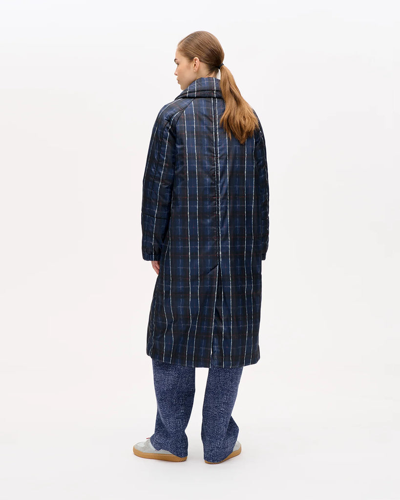 Długi, puchowy płaszcz Deana Navy Check o luźnym kroju z kołnierzem, elastycznymi ściągaczami przy mankietach, kieszeniami i rozcięciem z tyłu. Zapinana na napy. Posiada kieszeń na piersi i dwie kieszenie naszywane po bokach. Długość midi.
