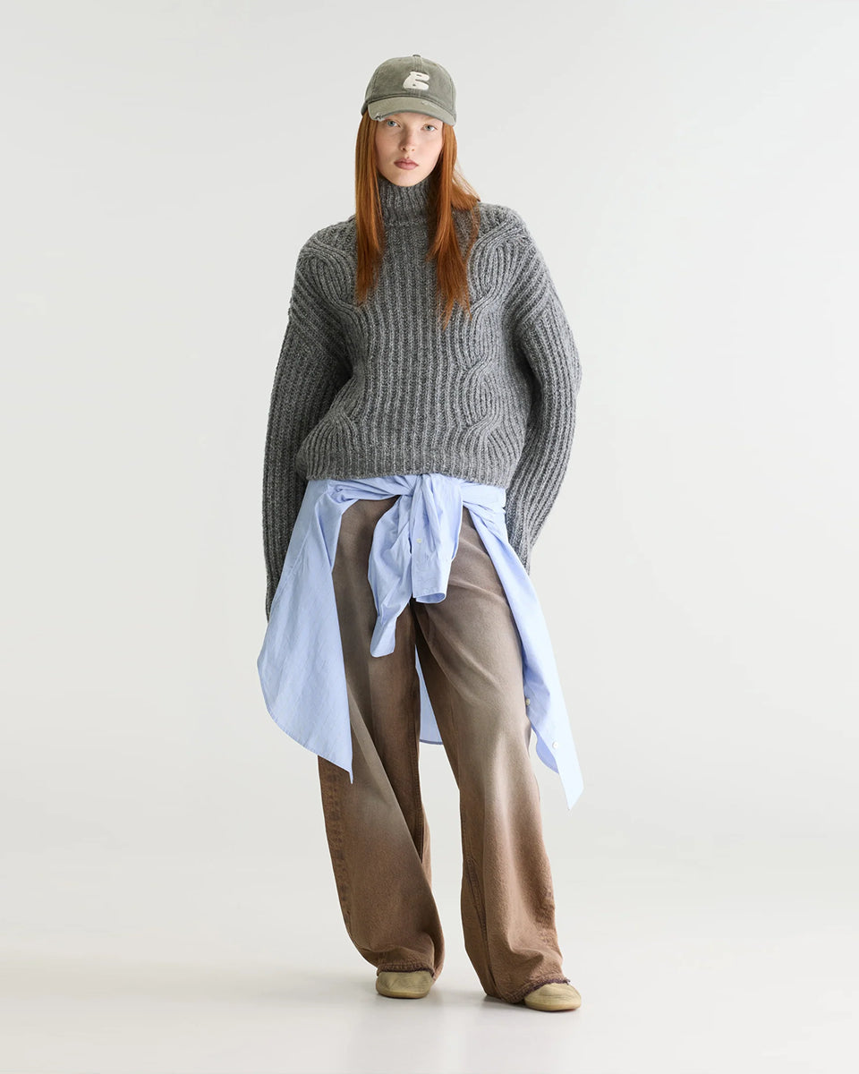 Szary sweter z golfem Deteo Mid Grey marki Bellerose o kroju oversize. Wykonany ściegiem typu "full cardigan", wyróżnia się bardzo grubym splotem ściągaczowym oraz dużymi wzorami warkoczowymi korpusie i rękawach.

-Krój oversize: celowo powiększony fason zapewniający obszerną, luźną sylwetkę

-Golf

-Warkoczowy splot&nbsp;