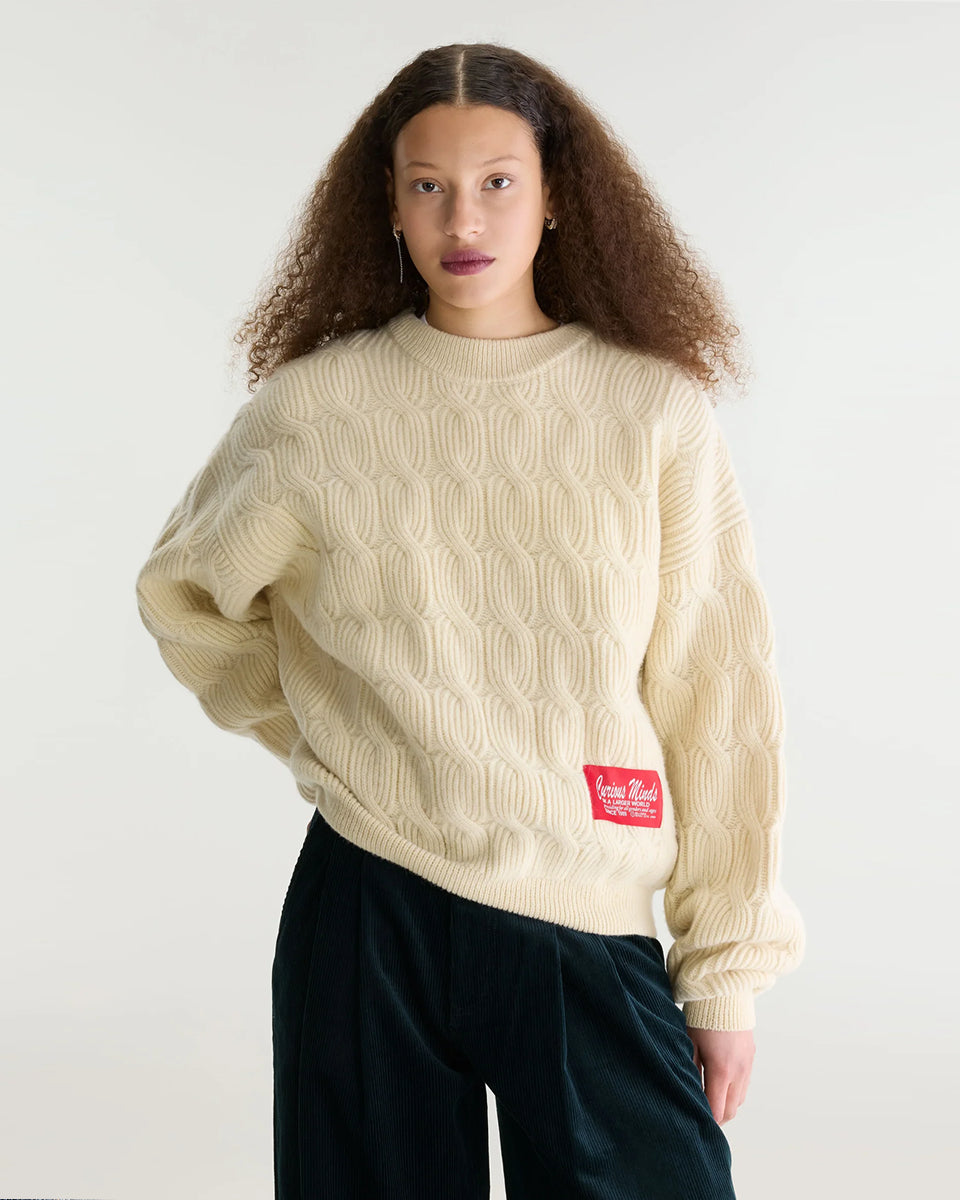 Sweter o luźnym kroju i okrągłym dekolcie Dole Ivory marki Bellerose wykonany z dzianiny w kolorze ecru o splocie ściągaczowym z motywem warkoczowym. Wyróżnia się obszerną górną częścią, zwężanym dołem, krótszym, dwuwarstwowym wykończeniem dekoltu oraz zewnętrzną naszywką.&nbsp;

-Luźny krój: zapewnia więcej swobody i komfortu w obrębie klatki piersiowej oraz ramion

-Splot ściągaczowy 1x1 z motywem warkoczowym

-Zwężany dół
