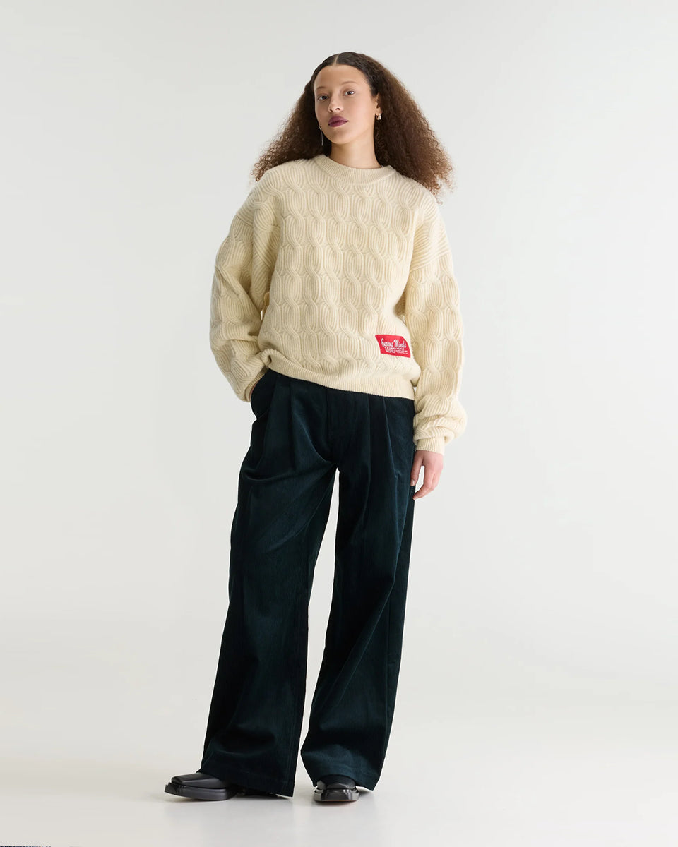 Sweter o luźnym kroju i okrągłym dekolcie Dole Ivory marki Bellerose wykonany z dzianiny w kolorze ecru o splocie ściągaczowym z motywem warkoczowym. Wyróżnia się obszerną górną częścią, zwężanym dołem, krótszym, dwuwarstwowym wykończeniem dekoltu oraz zewnętrzną naszywką.&nbsp;

-Luźny krój: zapewnia więcej swobody i komfortu w obrębie klatki piersiowej oraz ramion

-Splot ściągaczowy 1x1 z motywem warkoczowym

-Zwężany dół
