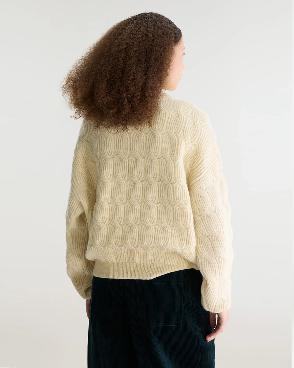 Sweter o luźnym kroju i okrągłym dekolcie Dole Ivory marki Bellerose wykonany z dzianiny w kolorze ecru o splocie ściągaczowym z motywem warkoczowym. Wyróżnia się obszerną górną częścią, zwężanym dołem, krótszym, dwuwarstwowym wykończeniem dekoltu oraz zewnętrzną naszywką.&nbsp;

-Luźny krój: zapewnia więcej swobody i komfortu w obrębie klatki piersiowej oraz ramion

-Splot ściągaczowy 1x1 z motywem warkoczowym

-Zwężany dół
