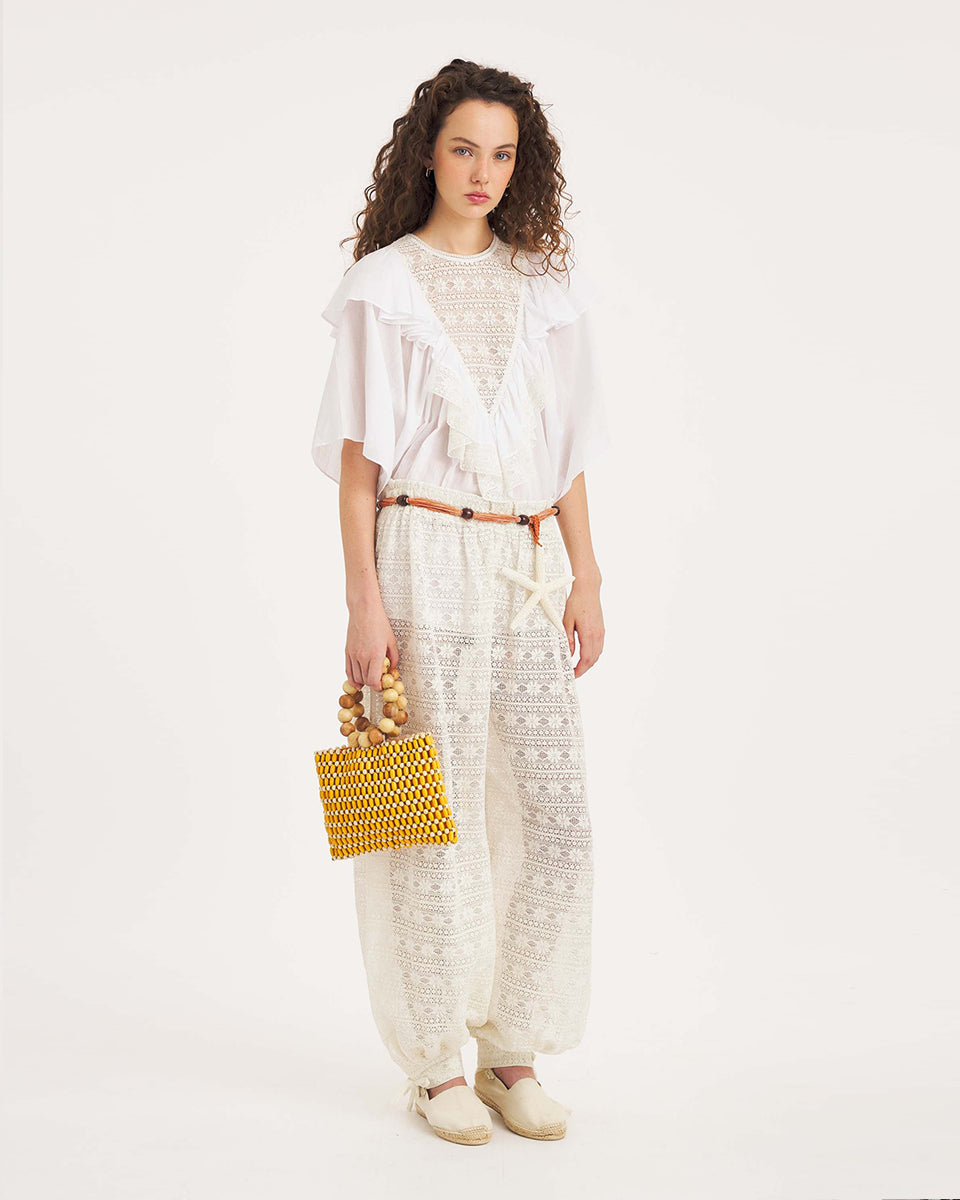 Luźna, biała bluzka Dolly White marki Antik Batik o swobodnym kroju, wyróżniającą się mocno romantycznym stylem boho. Z przodu jak i z tyłu posiada duży, ażurowy panel z misternej koronki o geometryczno- kwiatowym wzorze, który układa się w kształt litery V. Koronkowy dekolt zakończony jest szerokimi falbanami, które płynnie przechodzą w luźne, motylkowe rękawy o długości do łokcia. Z tyłu bluzka posiada subtelne rozcięcie w łezkę zapinane na guzik.&nbsp;

-Swobodny, luźny fason

-Falbany

-Koronka

-Zamów 