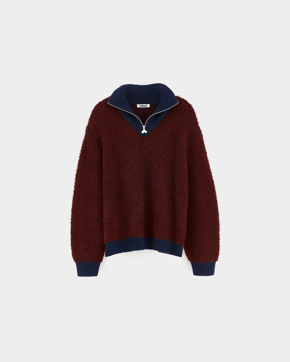 Sweter o klasycznym kroju z bordowej przędzy typu boucle Dooh Wine marki Bellerose wykonany splotem żakardowym imitującym fakturę ręcznika. Wyróżnia się kontrastowym, granatowym, podwójnym golfem z wełny merino, zapinanym na zamek błyskawiczny z uchwytem ozdobionym logo w kształcie serca.&nbsp;

-Krój regularny: zrównoważony fason, który podąża za naturalnymi liniami sylwetki

-Dwuwarstwowy golf zapinany na zamek

-Wyjątkowa przędza i splot żakardowy o fakturze ręcznika&nbsp;