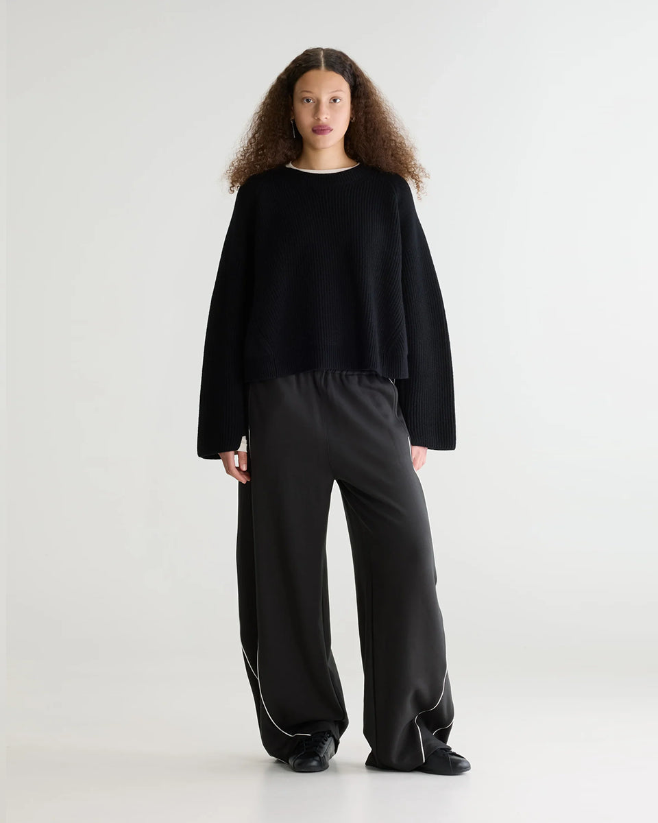 Luźny, krótki sweter z okrągłym dekoltem Dorou Black marki Bellerose wykonany z czarnej wełny merino, o średniej grubości dzianiny z panelami strukturalnymi. Posiada długie rękawy oraz ściągacze na mankietach i u dołu.

-Luźny krój: celowo powiększony, aby uzyskać obszerny wygląd.

-Krótszy fason