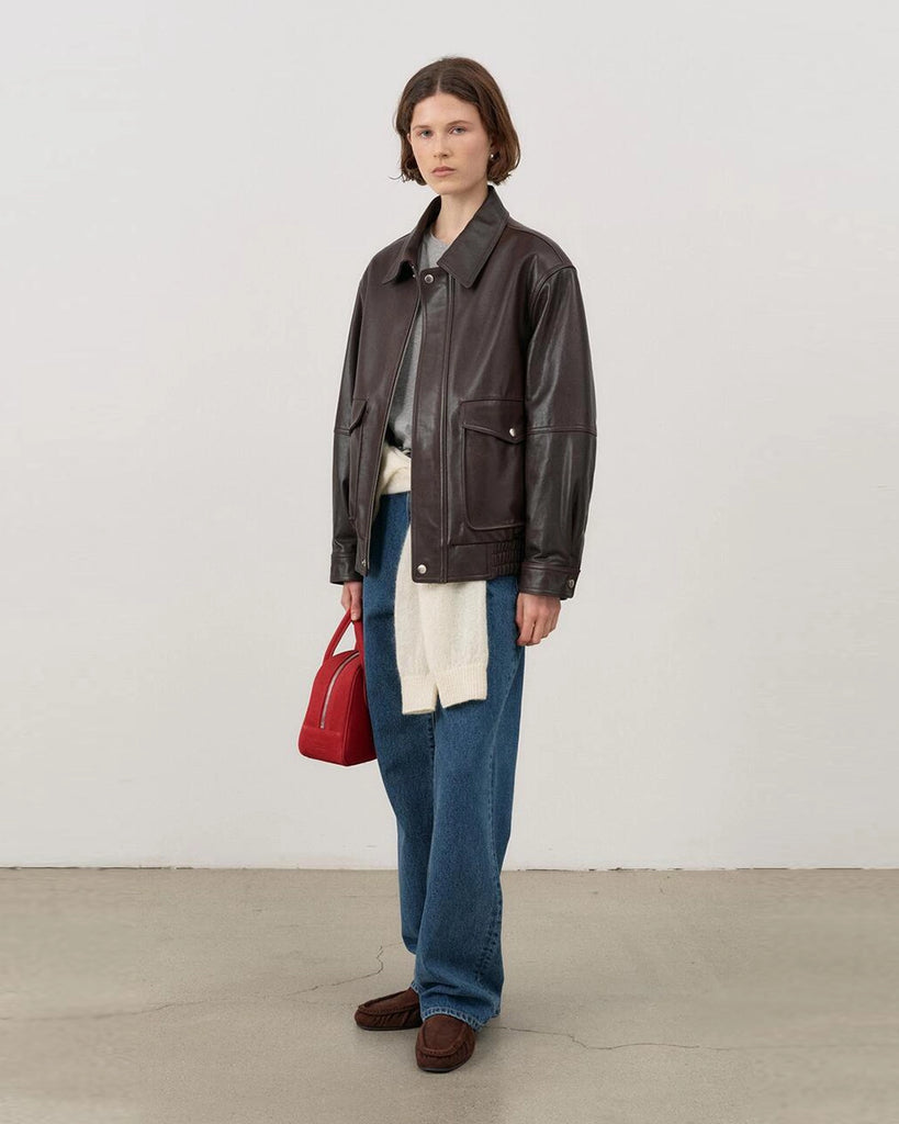 Luźna, brązowa skórzana kurtka Unisex Vintage Leather o prostym kroju i pudełkowym fasonie. Posiada kołnierzyk, luźne rękawy zapinane przy mankietach. Kurtka ma dwie, duże, prostokątne kieszenie z klapkami z przodu