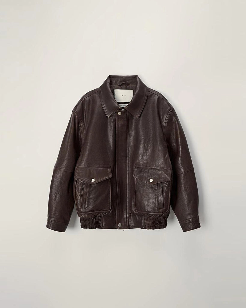 Luźna, brązowa skórzana kurtka Unisex Vintage Leather o prostym kroju i pudełkowym fasonie. Posiada kołnierzyk, luźne rękawy zapinane przy mankietach. Kurtka ma dwie, duże, prostokątne kieszenie z klapkami z przodu