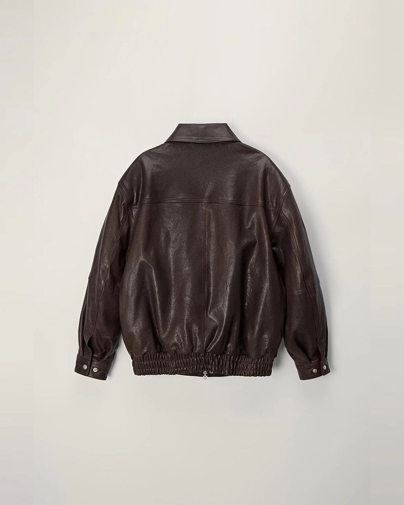 Luźna, brązowa skórzana kurtka Unisex Vintage Leather o prostym kroju i pudełkowym fasonie. Posiada kołnierzyk, luźne rękawy zapinane przy mankietach. Kurtka ma dwie, duże, prostokątne kieszenie z klapkami z przodu