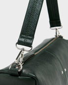 Torebka typu crossbody Duol Bottle Green marki BELLEROSE z teksturowanej, butelkowo-zielonej skóry koziej. Posiada regulowany, odpinany, beżowy pasek bawełniany oraz krótki, skórzany uchwyt. Zapinana na zamek błyskawiczny. Z przodu ma metalowe logo marki. Posiada wewnętrzną kieszeń główną, wewnętrzną kieszeń naszywaną oraz zewnętrzną kieszonkę boczną.&nbsp;