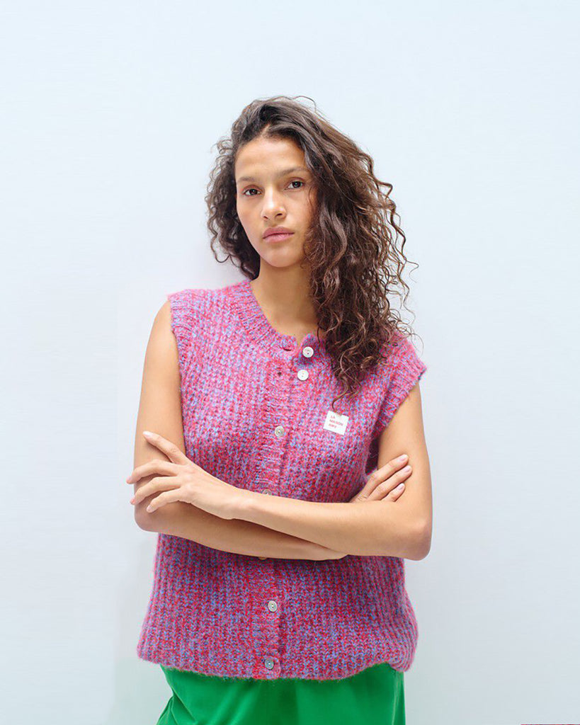 Krótki kardigan EAST19 Chili Red marki American Vintage bez rękawów, z okrągłym dekoltem i zapięciem na guziki. Posiada naszywkę z logo na piersi. Wyjątkowości &nbsp;i nowoczesności dodaje mu efekt uzyskany przez połączenie dwóch kontrastujących nici. Wykonany z puszystej dzianiny z alpaką i wełną. Niezbędny sweter, który można nosić samodzielnie lub na golf.&nbsp;