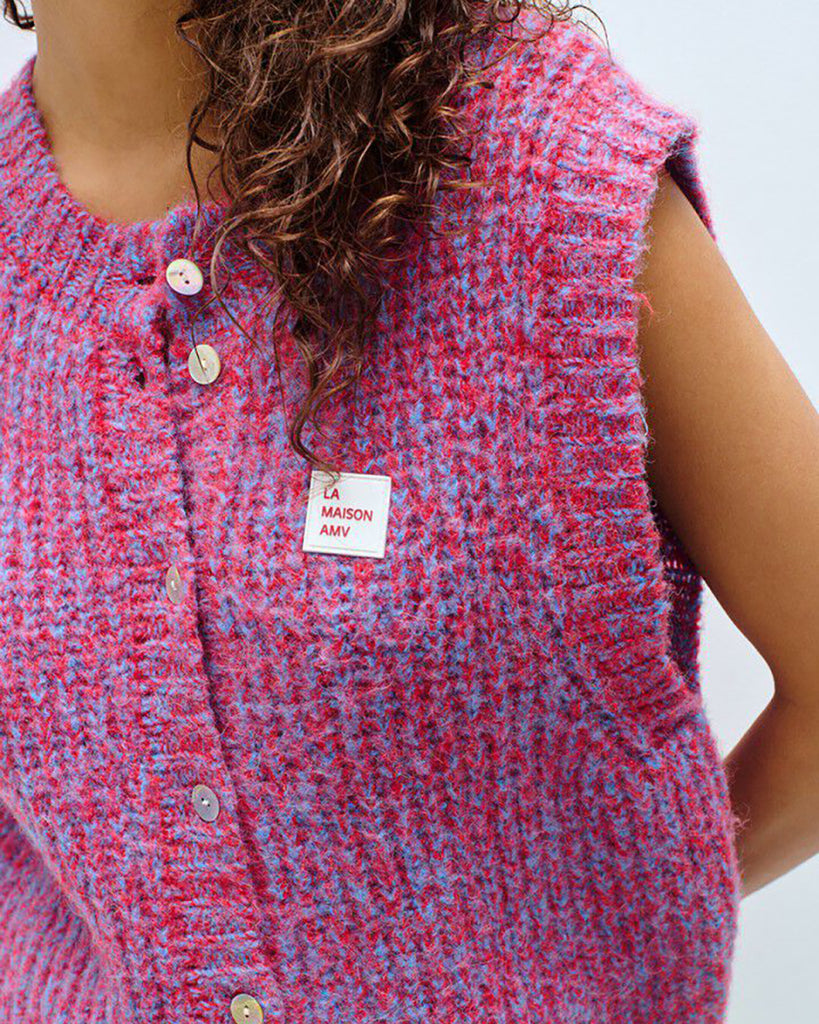 Krótki kardigan EAST19 Chili Red marki American Vintage bez rękawów, z okrągłym dekoltem i zapięciem na guziki. Posiada naszywkę z logo na piersi. Wyjątkowości &nbsp;i nowoczesności dodaje mu efekt uzyskany przez połączenie dwóch kontrastujących nici. Wykonany z puszystej dzianiny z alpaką i wełną. Niezbędny sweter, który można nosić samodzielnie lub na golf.&nbsp;