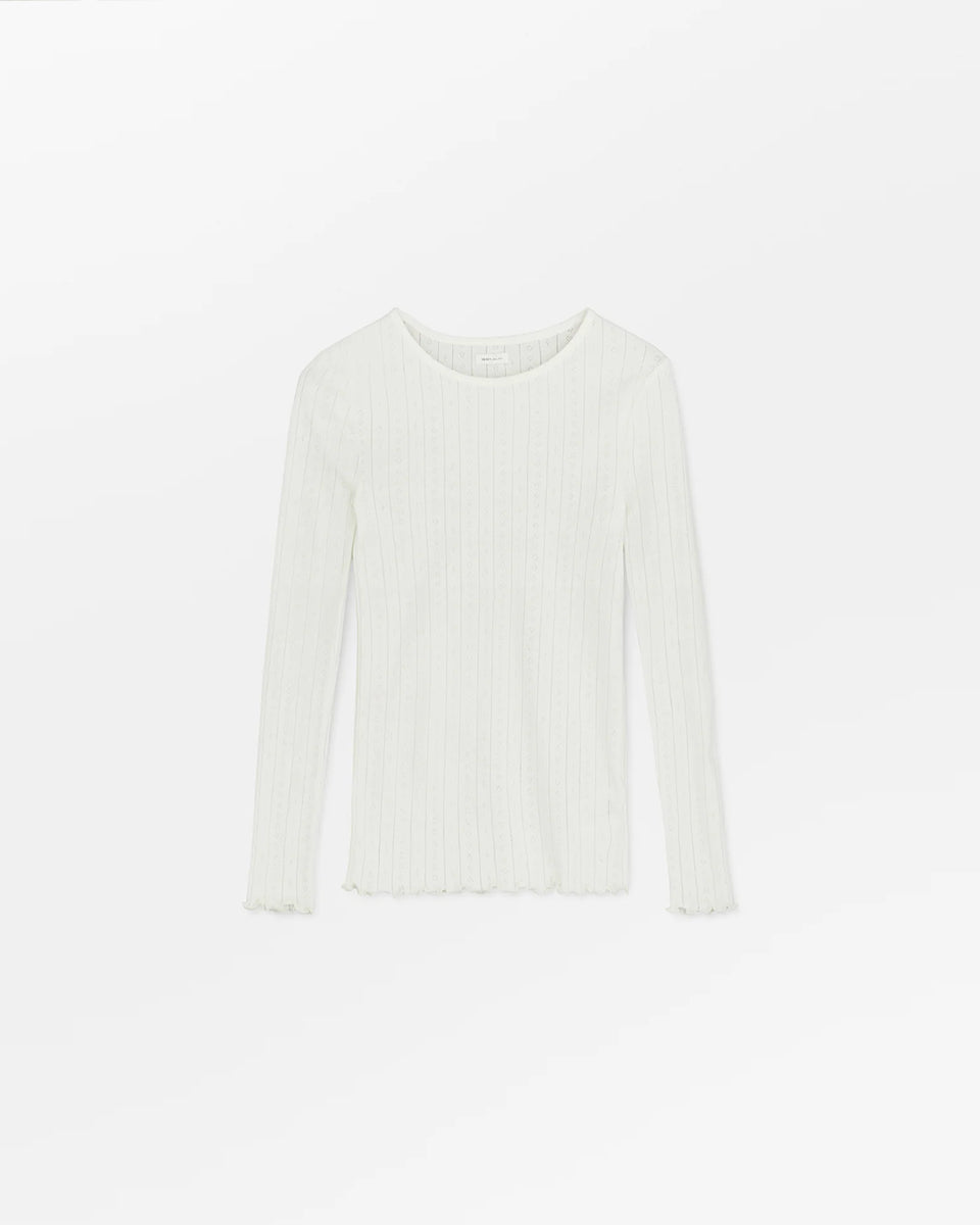 Cienki, biały longsleeve o przylegającym fasonie Edie SKALL. Posiada okrągły dekolt i wąskie, długie rękawy. Wykonany z miękkiej, bawełnianej tkaniny z delikatnym, ażurowym wzorem. U dołu i przy nadgarstkach wykończony falbanką.&nbsp;

-Przylegający fason&nbsp;

-100% bawełna organiczna

-Zamów bluzkę w swoim normalnym rozmiarze