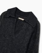 Ciemnoszary, miękki sweter polo Elara TNS Dark Grey Melange z kołnierzykiem, obniżoną linią ramion i ściągaczami. Ma swobodny krój, czyniąc ją ponadczasową dzianiną idealną do codziennych, swobodnych stylizacji. Wykonany z luksusowej mieszanki alpaki i wełny dziewiczej.&nbsp;

-Obniżona linia ramion&nbsp;

-Kołnierzyk polo

-Zamów sweter w swoim normalnym rozmiarze&nbsp;