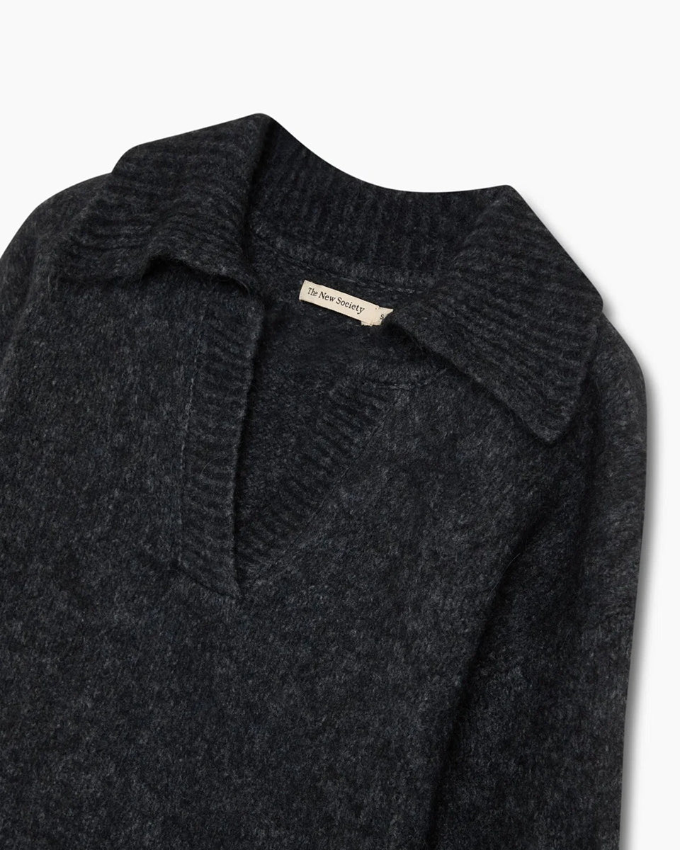 Ciemnoszary, miękki sweter polo Elara TNS Dark Grey Melange z kołnierzykiem, obniżoną linią ramion i ściągaczami. Ma swobodny krój, czyniąc ją ponadczasową dzianiną idealną do codziennych, swobodnych stylizacji. Wykonany z luksusowej mieszanki alpaki i wełny dziewiczej.&nbsp;

-Obniżona linia ramion&nbsp;

-Kołnierzyk polo

-Zamów sweter w swoim normalnym rozmiarze&nbsp;