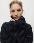 Ciemnoszary, miękki sweter polo Elara TNS Dark Grey Melange z kołnierzykiem, obniżoną linią ramion i ściągaczami. Ma swobodny krój, czyniąc ją ponadczasową dzianiną idealną do codziennych, swobodnych stylizacji. Wykonany z luksusowej mieszanki alpaki i wełny dziewiczej.&nbsp;

-Obniżona linia ramion&nbsp;

-Kołnierzyk polo

-Zamów sweter w swoim normalnym rozmiarze&nbsp;
