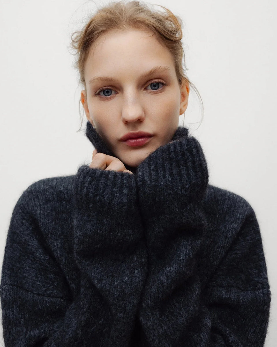 Ciemnoszary, miękki sweter polo Elara TNS Dark Grey Melange z kołnierzykiem, obniżoną linią ramion i ściągaczami. Ma swobodny krój, czyniąc ją ponadczasową dzianiną idealną do codziennych, swobodnych stylizacji. Wykonany z luksusowej mieszanki alpaki i wełny dziewiczej.&nbsp;

-Obniżona linia ramion&nbsp;

-Kołnierzyk polo

-Zamów sweter w swoim normalnym rozmiarze&nbsp;