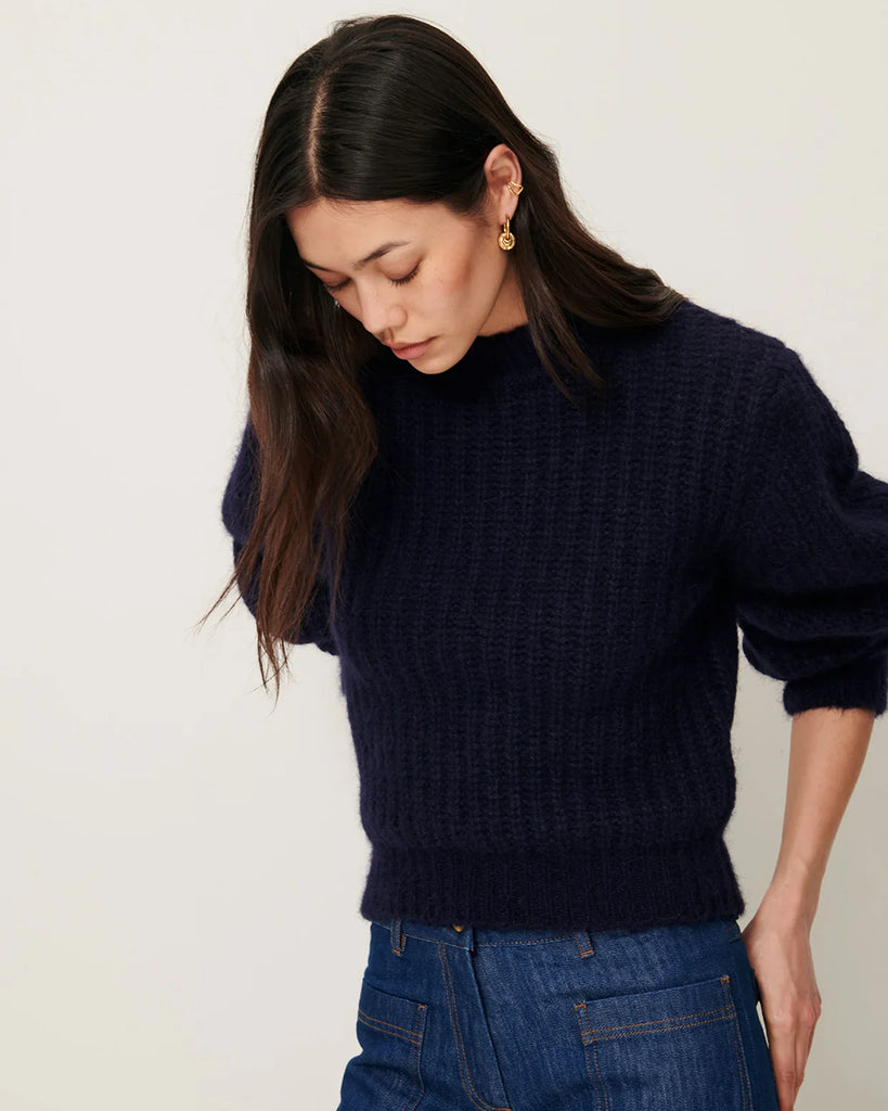Granatowy sweter Eole Navy francuskiej marki Sessun z okrągłym dekoltem i długimi bufiastymi rękawami. Wykonany z puszystej dzianiny typu half-cardigan.&nbsp;
