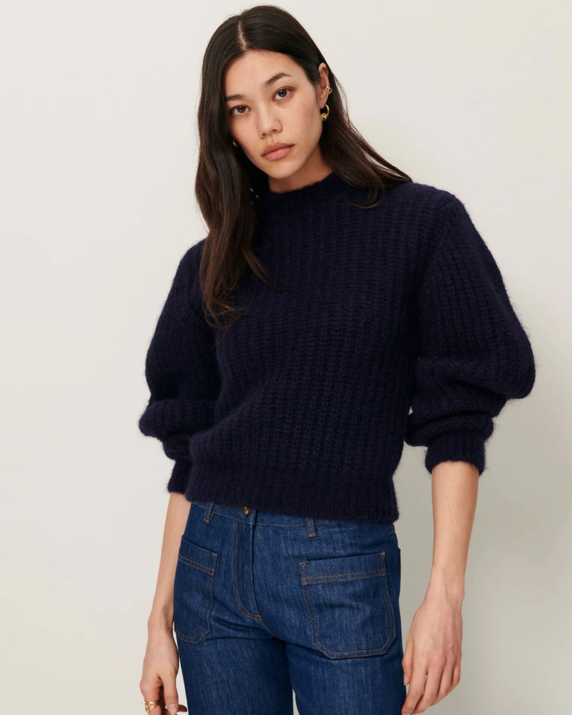 Granatowy sweter Eole Navy francuskiej marki Sessun z okrągłym dekoltem i długimi bufiastymi rękawami. Wykonany z puszystej dzianiny typu half-cardigan.&nbsp;
