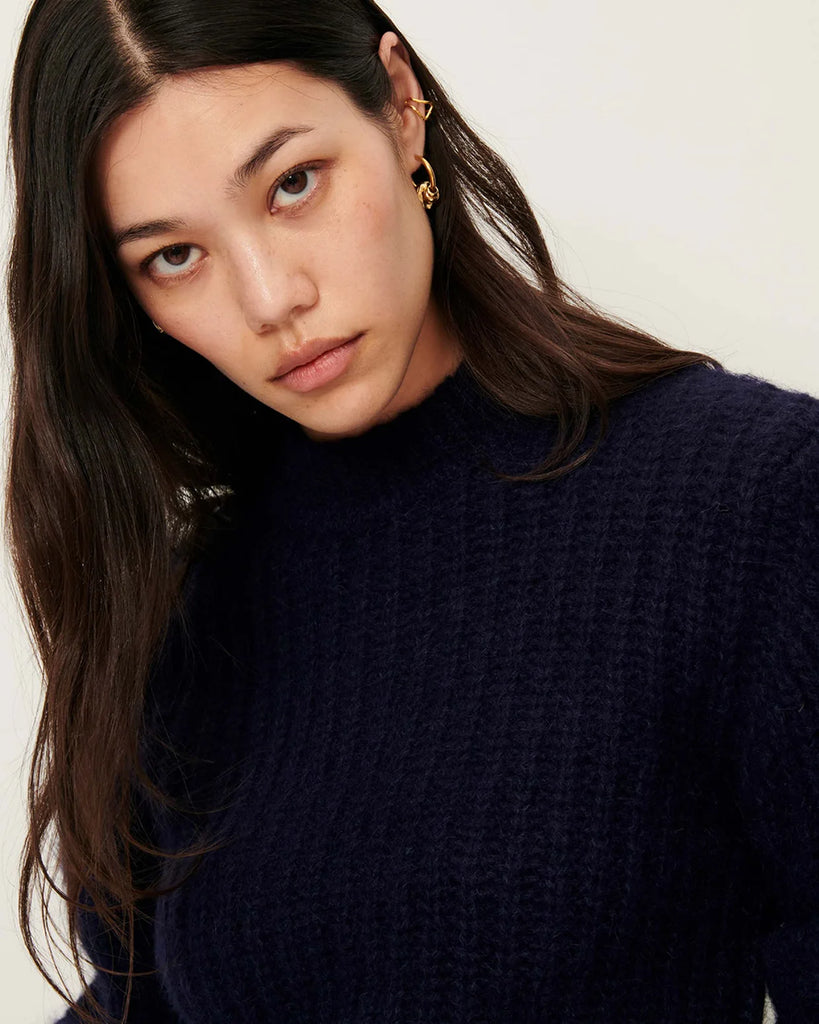 Granatowy sweter Eole Navy francuskiej marki Sessun z okrągłym dekoltem i długimi bufiastymi rękawami. Wykonany z puszystej dzianiny typu half-cardigan.&nbsp;
