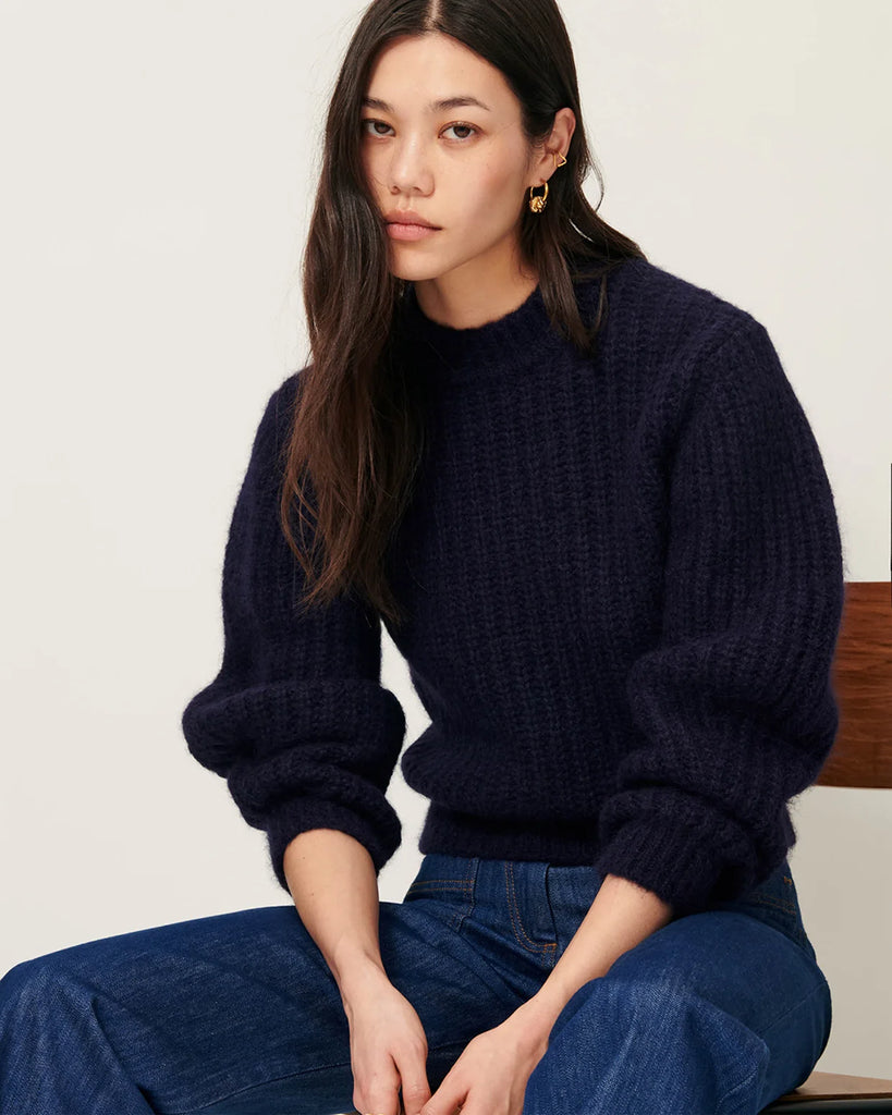 Granatowy sweter Eole Navy francuskiej marki Sessun z okrągłym dekoltem i długimi bufiastymi rękawami. Wykonany z puszystej dzianiny typu half-cardigan.&nbsp;
