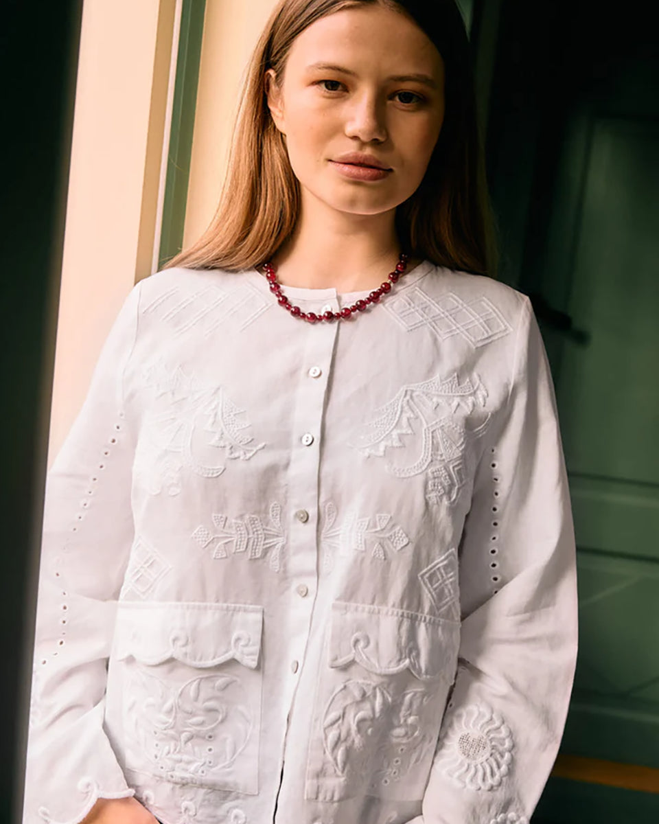Koszula Ester Ecru marki SISSEL EDELBO to kobiecy, romantyczny model wykonany z miękkiej mieszanki bawełny organicznej i lnu. Posiada plaski kołnierzyk, dwie kieszenie z przodu oraz jasne guziki z masy perłowej wzdłuż zapięcia. Koszulę zdobią delikatne hafty i piękne ażurowe detale. Ma swobodny, luźny krój.&nbsp;

-Delikatne hafty i ażurowe detale

-Miękka mieszanka bawełny i lnu

-Swobodny krój