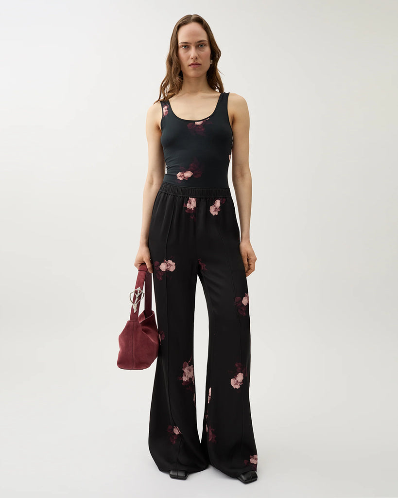 Zwiewne, lejące spodnie Ezra Wine Black w kwiatowy print z elastycznym pasem na gumce i kieszeniami po bokach. Mają wysoki stan i rozszerzaną nogawkę.&nbsp;