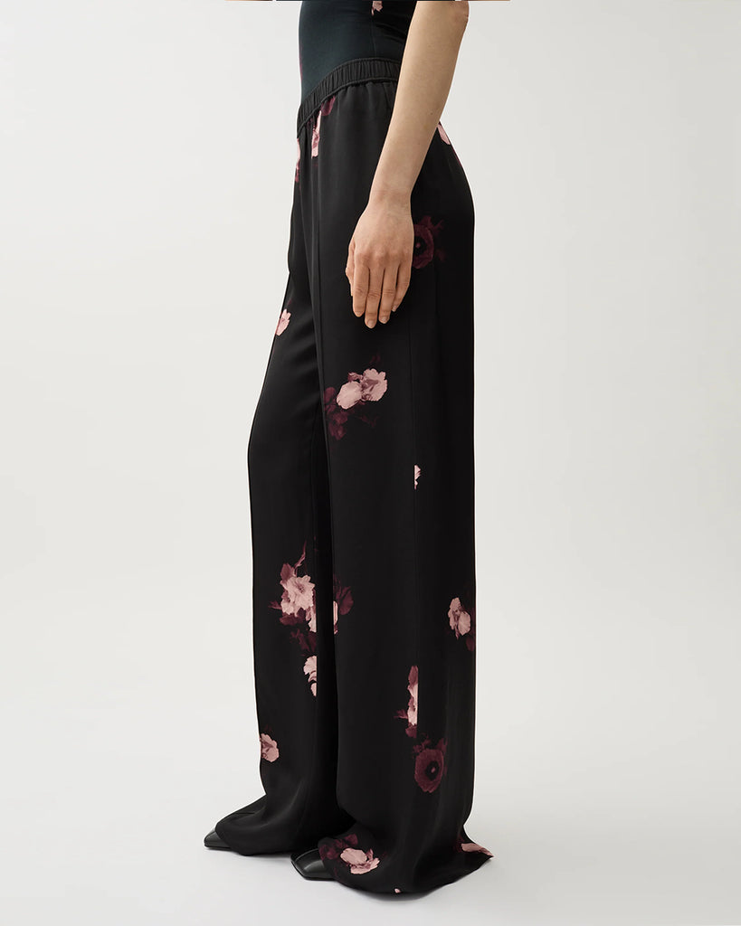 Zwiewne, lejące spodnie Ezra Wine Black w kwiatowy print z elastycznym pasem na gumce i kieszeniami po bokach. Mają wysoki stan i rozszerzaną nogawkę.&nbsp;