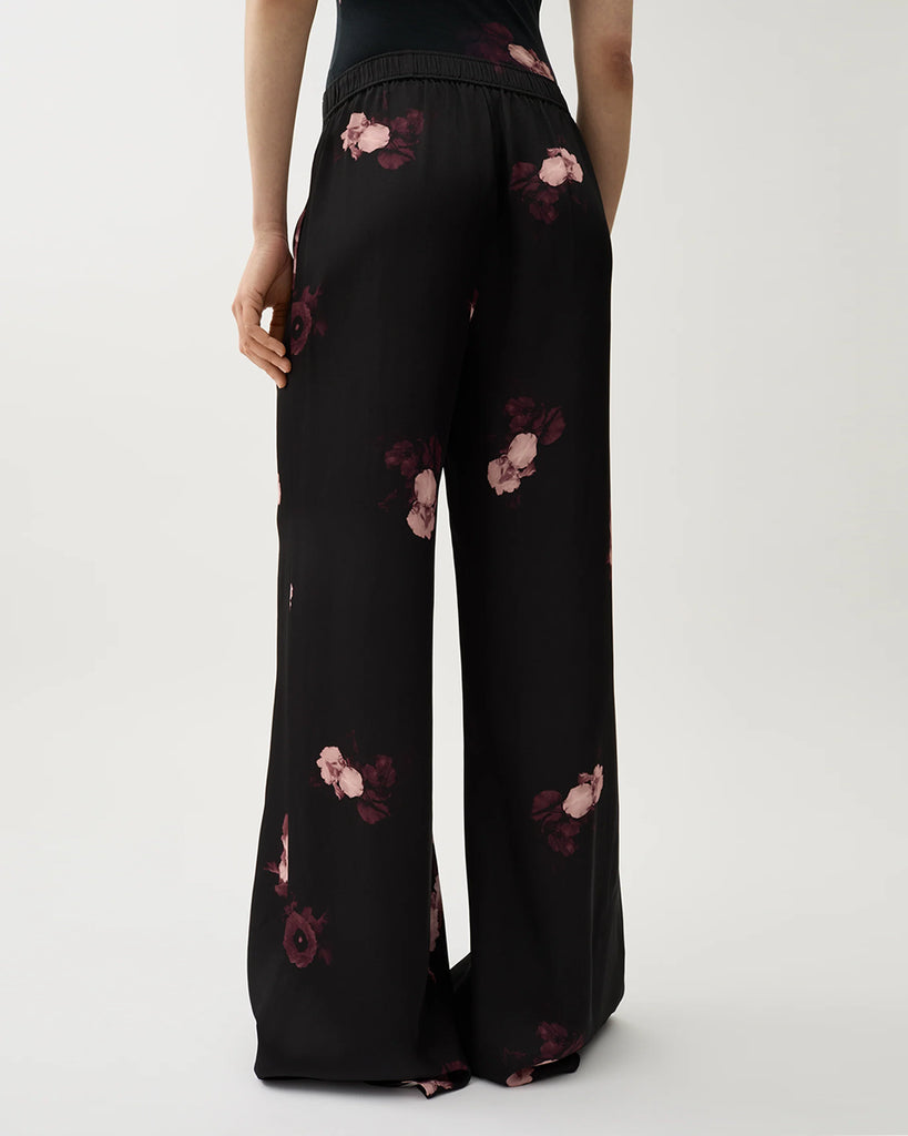 Zwiewne, lejące spodnie Ezra Wine Black w kwiatowy print z elastycznym pasem na gumce i kieszeniami po bokach. Mają wysoki stan i rozszerzaną nogawkę.&nbsp;