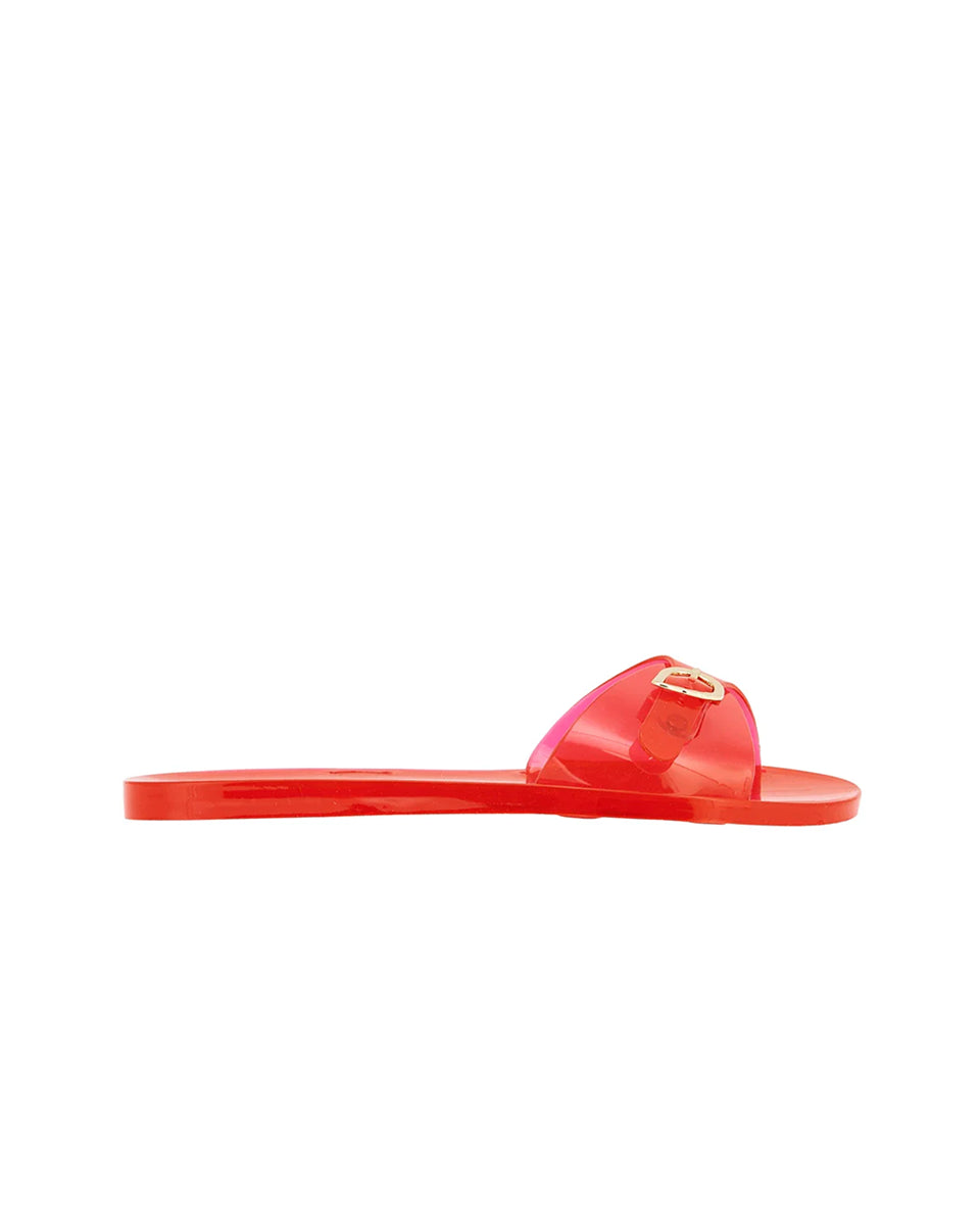 Swobodne, minimalistyczne klapki typu slide Filia Jelly Red na całkowicie płaskiej podeszwie. Mają intensywny odcień czerwieni, o półprzezroczystym wykończeniu. Posiadają jeden, szeroki, asymetryczny pasek ze złotą klamrą w kształcie skrzydełek. Na wkładce widoczne jest wytłoczone logo marki. Wykonane z elastycznej, wodoodpornej gumy/PVC, co czyni je idealnym wyborem jako stylowe obuwie plażowe.&nbsp;