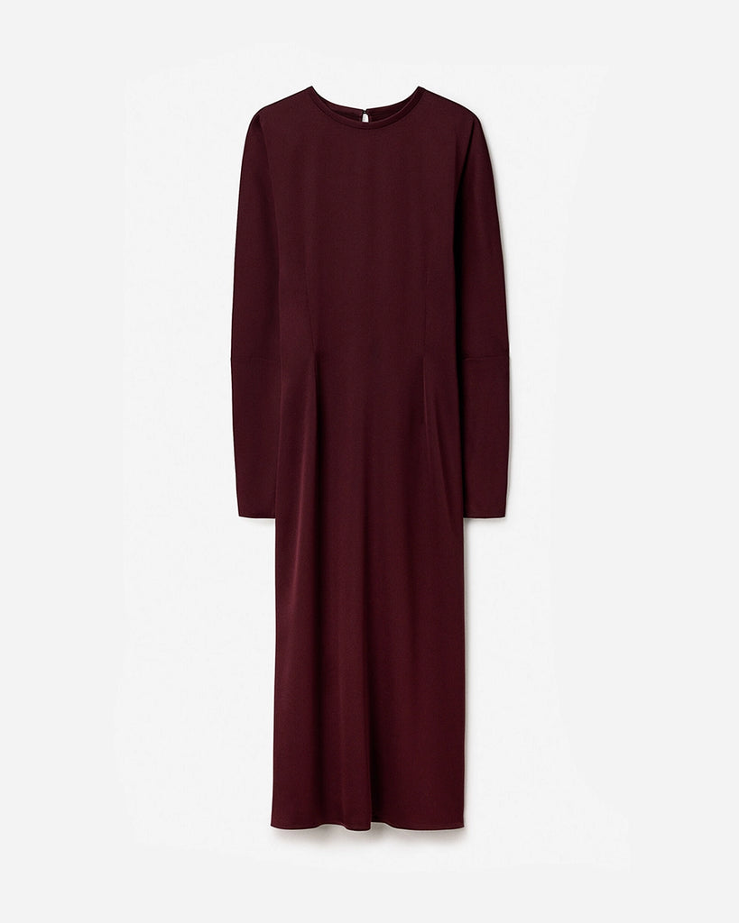 Minimalistyczna, luźna, elegancka sukienka midi Filippa K z okrągłym dekoltem i długimi rękawami rozszerzanymi pod pachami z guzikami przy mankietach. Na plecach posiada długie, wąskie rozcięcie. Z tyłu przy szyi zapinana na jeden guzik. Lekko zwężana w talii. Z tyłu w pasie ma elastyczną gumkę.