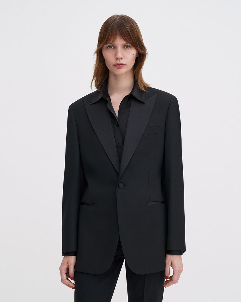 Klasyczna, jednorzędowa marynarka smokingowa Filippa K Hourglass Tuxedo z szerokimi ramionami i dopasowaną talią, która tworzy sylwetkę klepsydry. Zapinana na guzik z przodu. Noś ją z dopasowanymi spodniami, aby uzyskać wyrazisty look idealny na wieczorowe okazje.&nbsp;