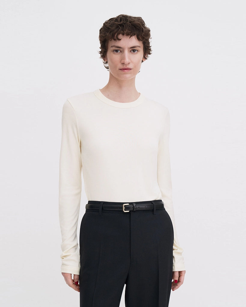 Luźny, minimalistyczny longsleeve Filippa K z okrągłym dekoltem i długimi rękawami. Top ma prosty krój. Jest wykonany z bardzo miękkiej i lejącej tkaniny z prążkowaną fakturą.