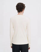 Luźny, minimalistyczny longsleeve Filippa K z okrągłym dekoltem i długimi rękawami. Top ma prosty krój. Jest wykonany z bardzo miękkiej i lejącej tkaniny z prążkowaną fakturą.