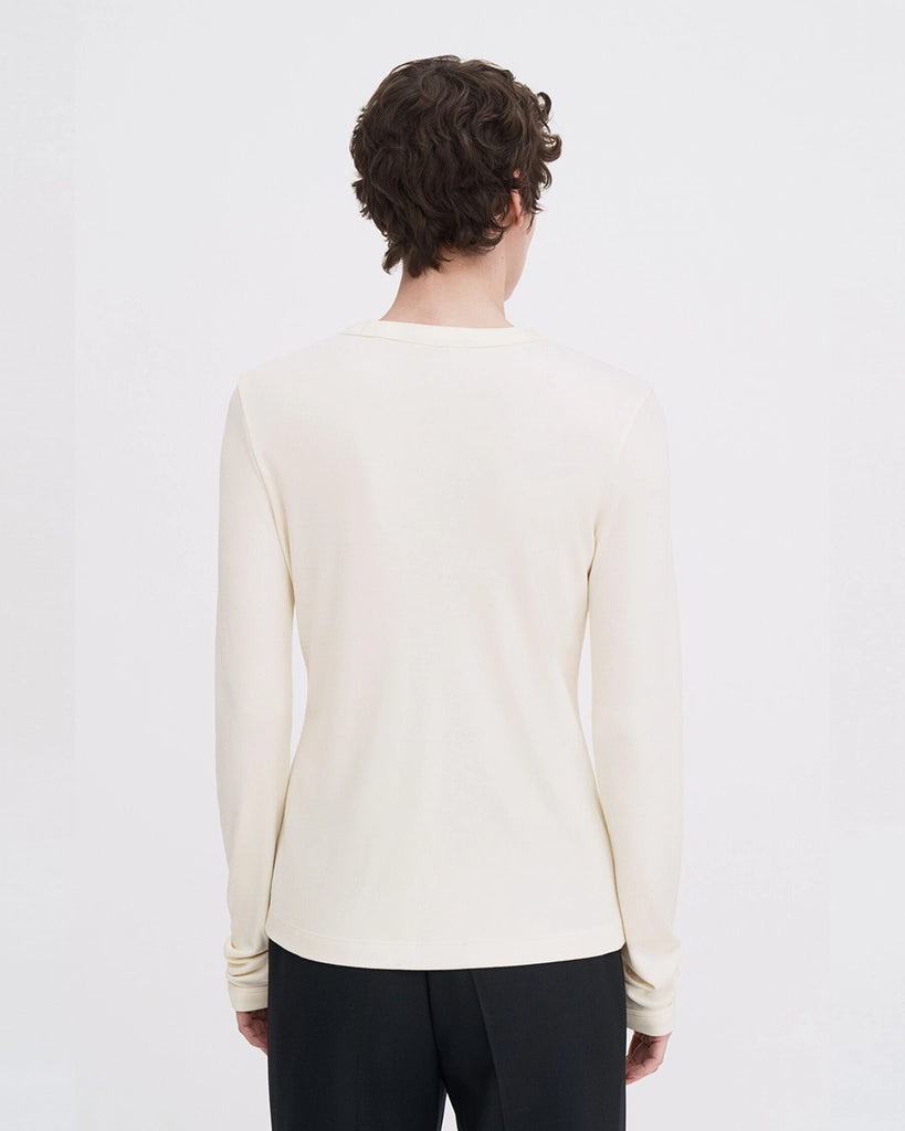 Luźny, minimalistyczny longsleeve Filippa K z okrągłym dekoltem i długimi rękawami. Top ma prosty krój. Jest wykonany z bardzo miękkiej i lejącej tkaniny z prążkowaną fakturą.