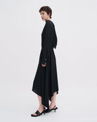 Minimalistyczna, luźna, elegancka sukienka midi Filippa K z wysokim dekoltem w formie golfu i wiązaniem z tyłu przy szyi. Sukienka ma długie rękawy zakończone mankietami oraz efektowne, wąskie rozcięcie na plecach. Z przodu marszczona przy dekolcie i i talii. U dołu wykończona asymetrycznie