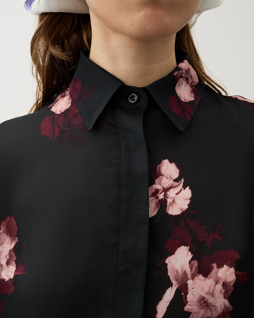 Zwiewna, koszulowa bluzka Finch Wine Black w kolorze czarnym z kwiatowym printem. Posiada klasyczny kołnierzyk i asymetryczne rękawy. Zapinana jest na ukryte guziki. Stwórz idealny set ze spodniami Ezra tej samej marki.&nbsp;